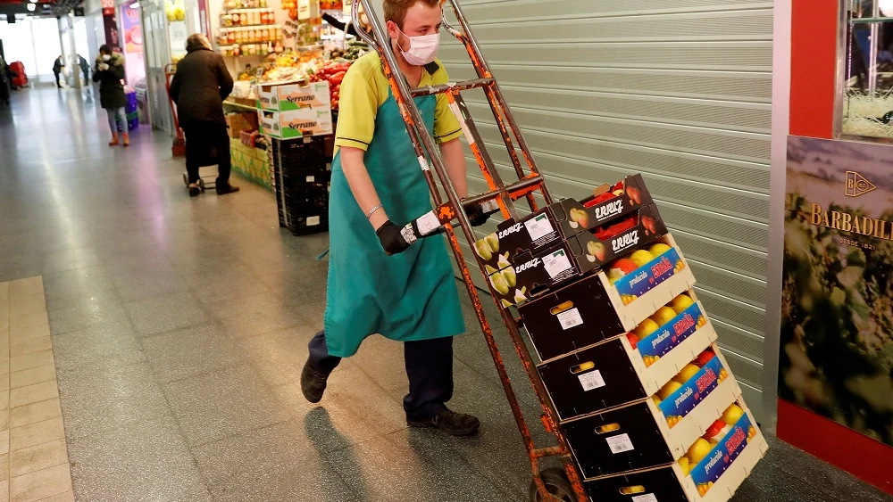 Imagen de un hombre transportando alimentos en un mercado