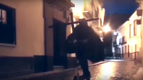 Un hombre vestido de nazareno monta en patinete eléctrico por las calles de Utrera Un hombre vestido de nazareno monta en patinete eléctrico por las calles de Utrera