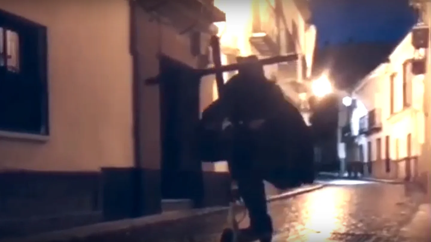 Un hombre vestido de nazareno monta en patinete eléctrico por las calles de Utrera Un hombre vestido de nazareno monta en patinete eléctrico por las calles de Utrera