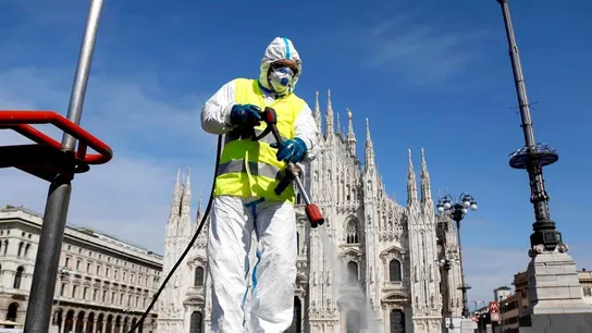 Imagen de una persona limpiando las calles en Italia con una mascarilla Imagen de una persona limpiando las calles en Italia con una mascarilla