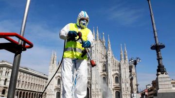 Imagen de una persona limpiando las calles en Italia con una mascarilla