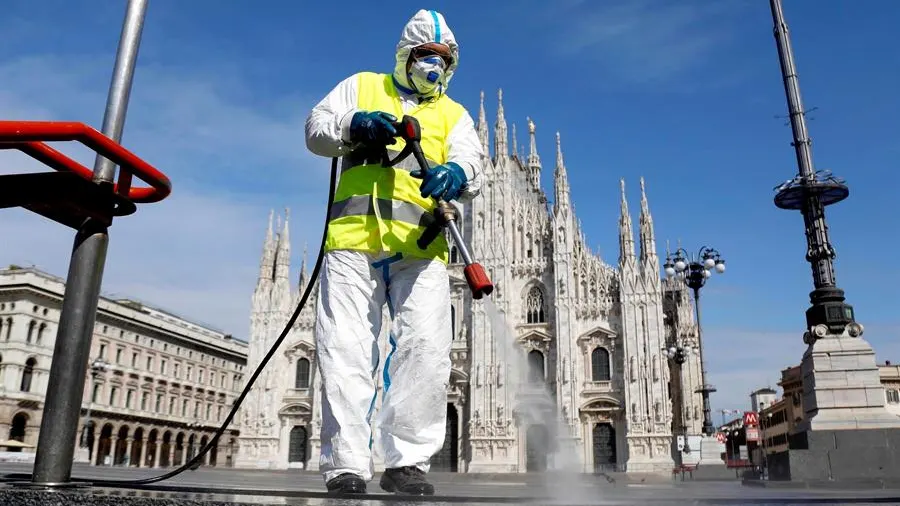 Imagen de una persona limpiando las calles en Italia con una mascarilla