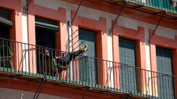 Un hombre toma el sol y lee en un balcón en Córdoba, durante la cuarentena