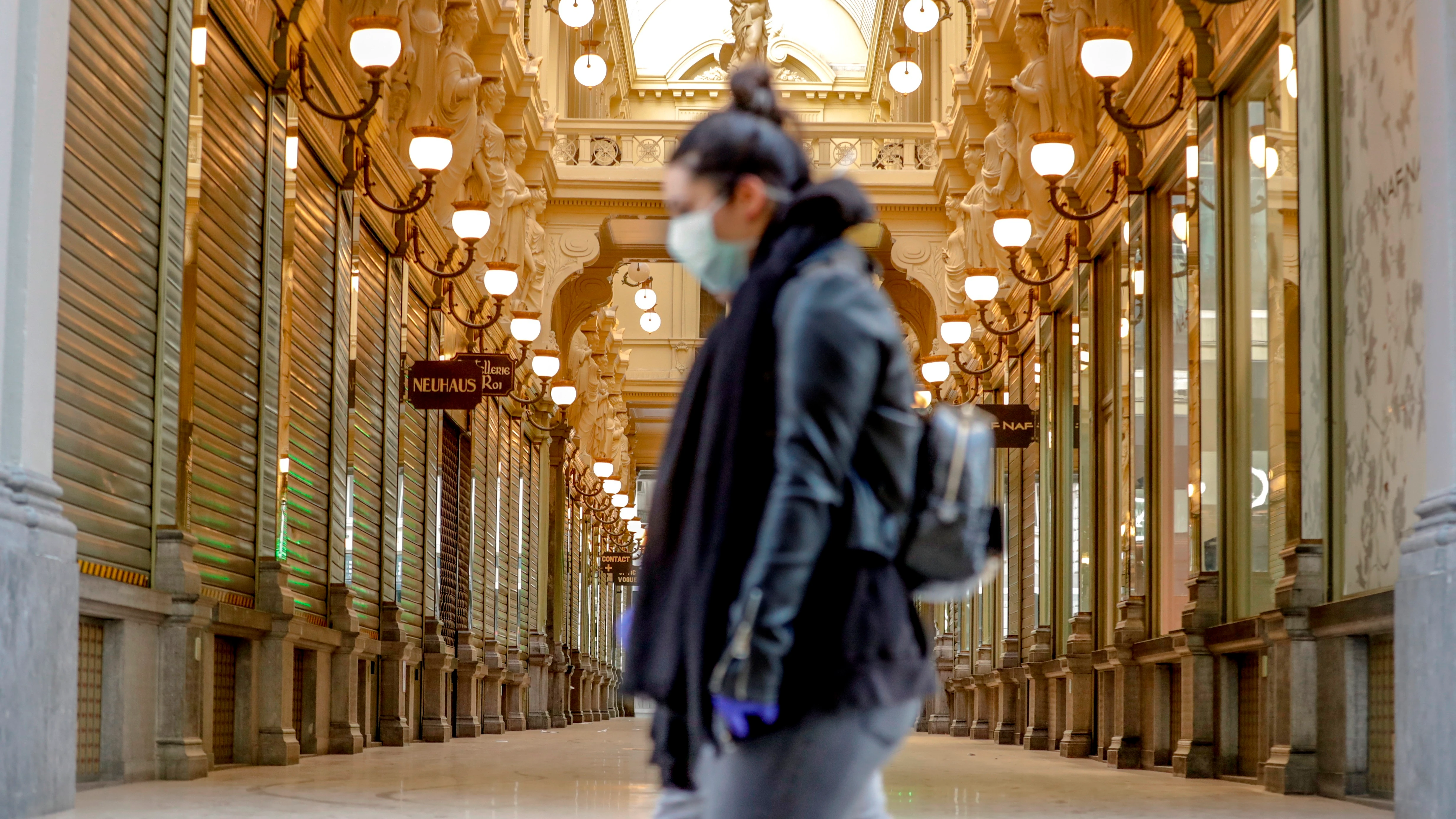 Una mujer pasea por Bruselas con mascarilla