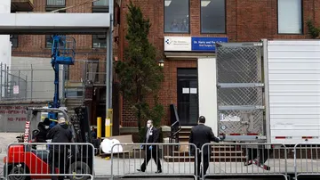 Los empleados del hospital trasladan un cuerpo a una morgue móvil