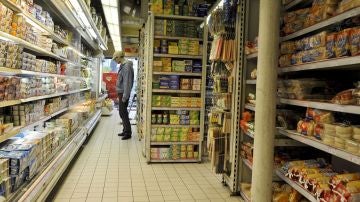 Un cliente observando las estanterías de un supermercado