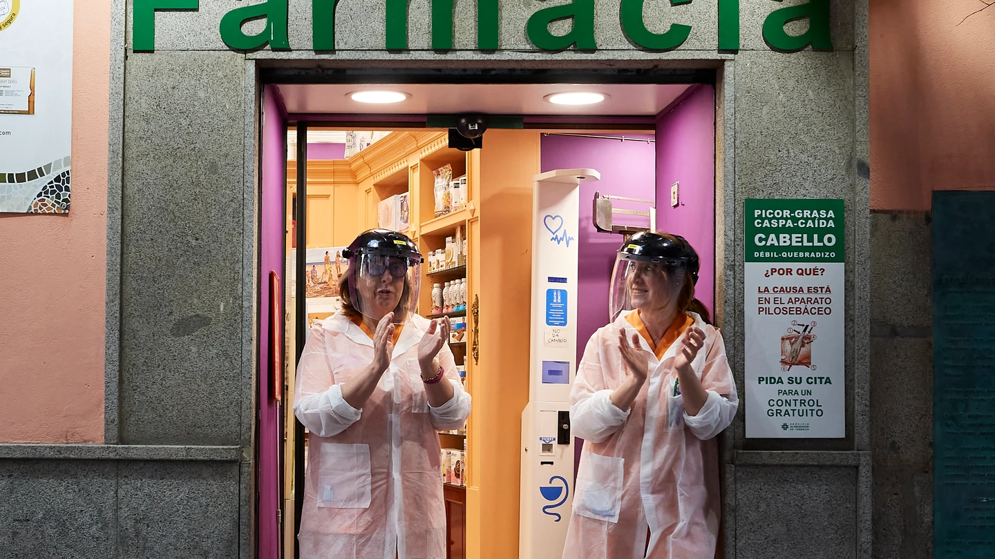 Dos farmacéuticas aplauden a la puerta de su farmacia Dos farmacéuticas aplauden a la puerta de su farmacia