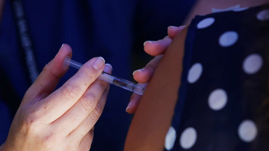 Una sanitaria pone una inyección a una paciente Una sanitaria pone una inyección a una paciente