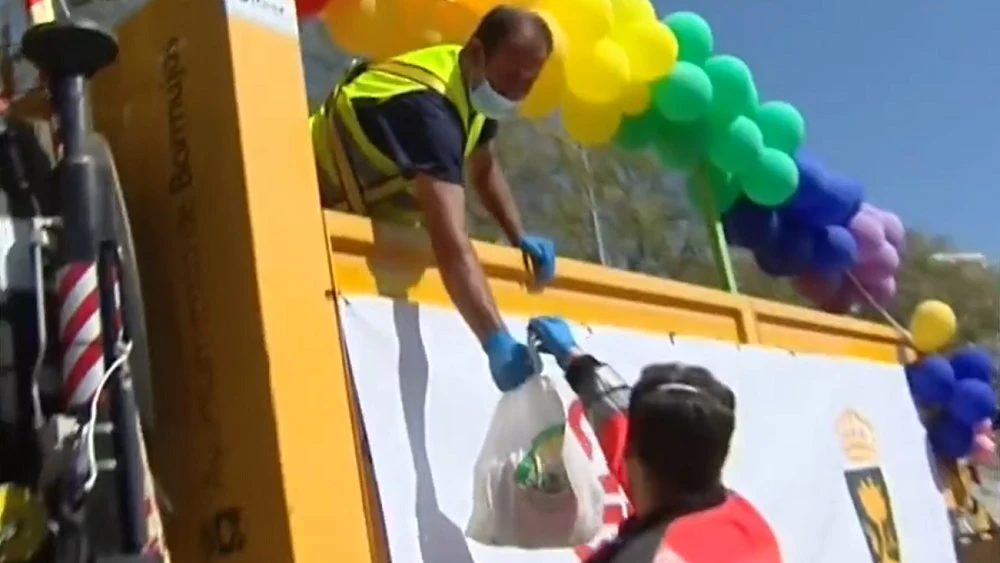 Imagen de una persona recogiendo comida en Bormujos para los más vulnerables