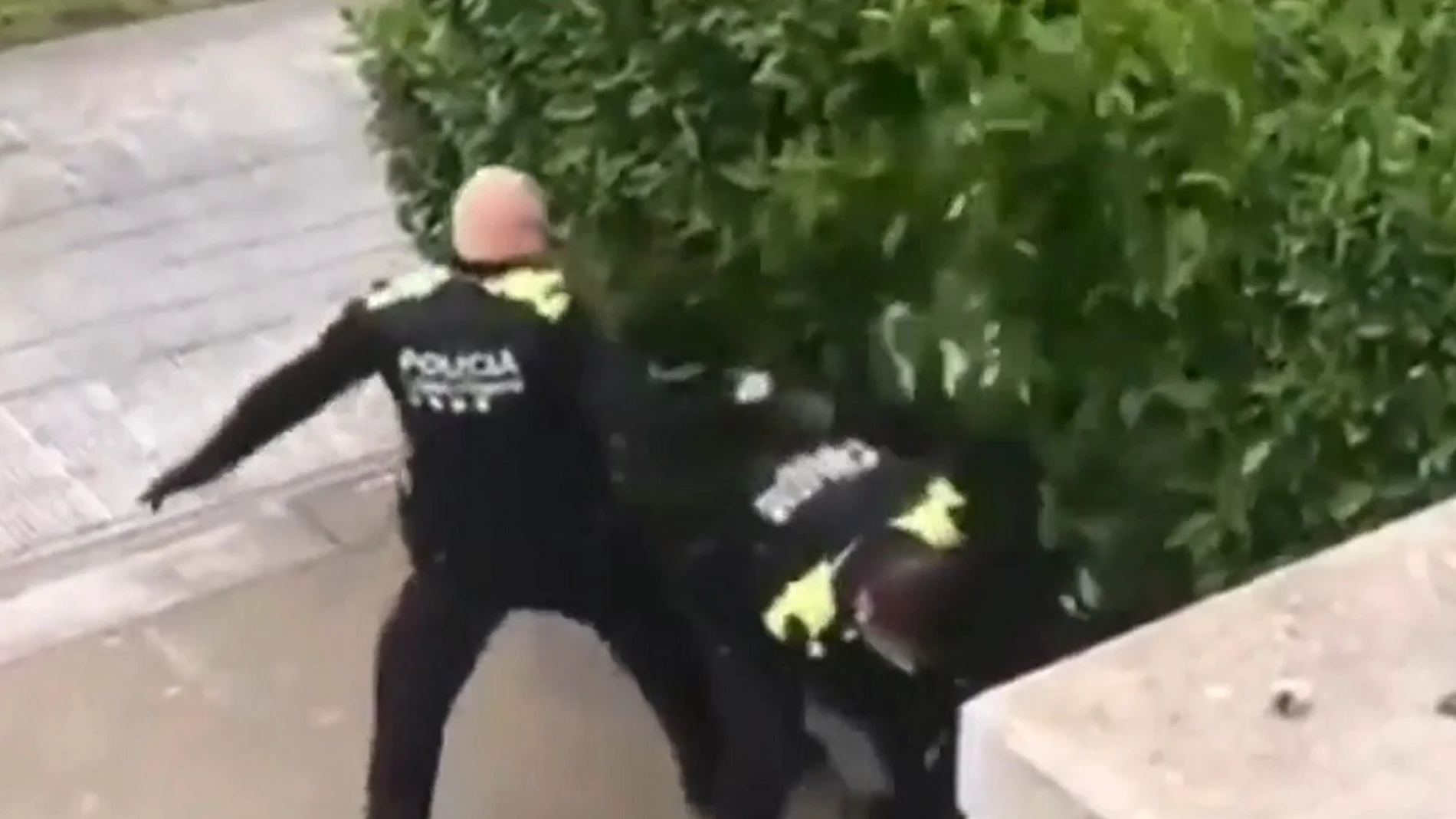 Imagen de dos policías agrediendo a dos jóvenes en Girona