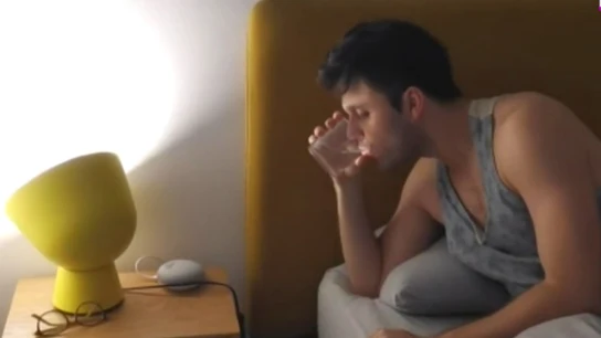 Imagen de un joven tomando medicamentos para dormir Imagen de un joven tomando medicamentos para dormir