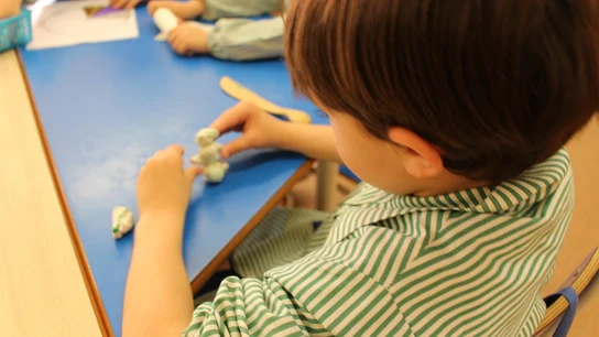 Imagen de archivo de un niño haciendo manualidades en una escuela infantil Imagen de archivo de un niño haciendo manualidades en una escuela infantil