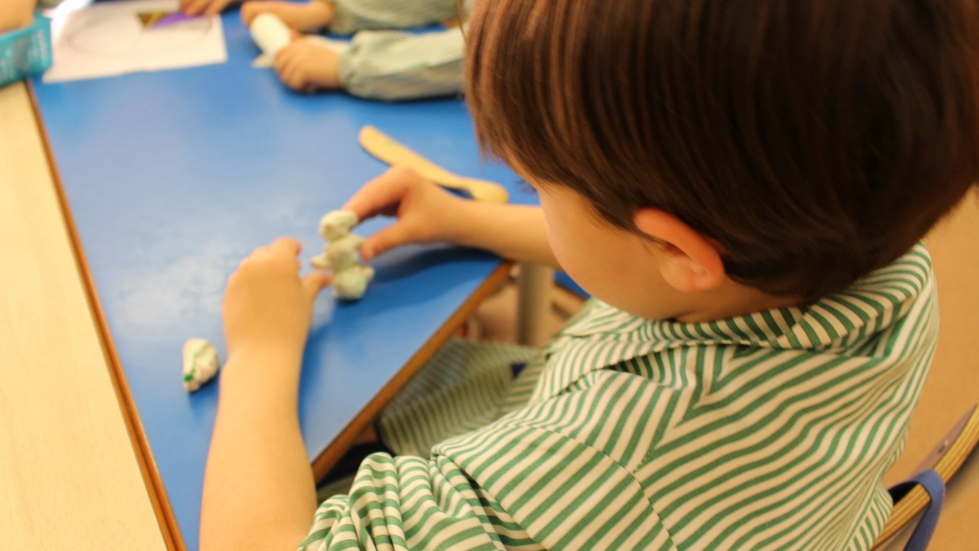 Imagen de archivo de un niño haciendo manualidades en una escuela infantil