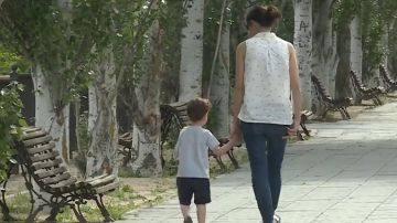 Una mujer pasea con un niño por la calle