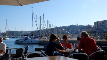 Gente disfrutando de una terraza frente al mar, en el Paseo Marítimo de Palma.