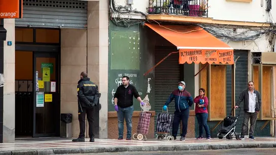 Varias personas hacen cola para entrar en un supermercado.  Varias personas hacen cola para entrar en un supermercado.