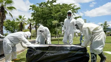 Trabajadores del cementerio Parque de la Paz entierran a un fallecido