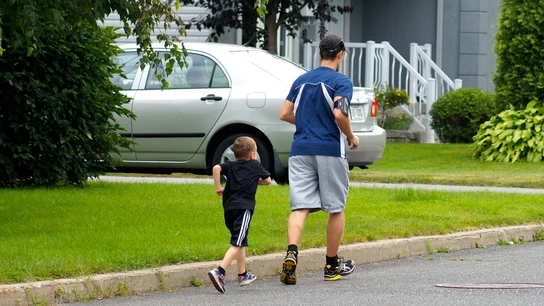 Un niño corre junto a su padre por la calle Un niño corre junto a su padre por la calle