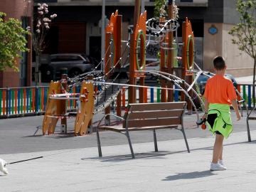 Un niño pasea el perro junto a un parque cerca de su casa en Bilbao Un niño pasea el perro junto a un parque cerca de su casa en Bilbao