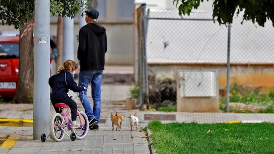 Una niña pasea junto a su padre en bicicleta Una niña pasea junto a su padre en bicicleta