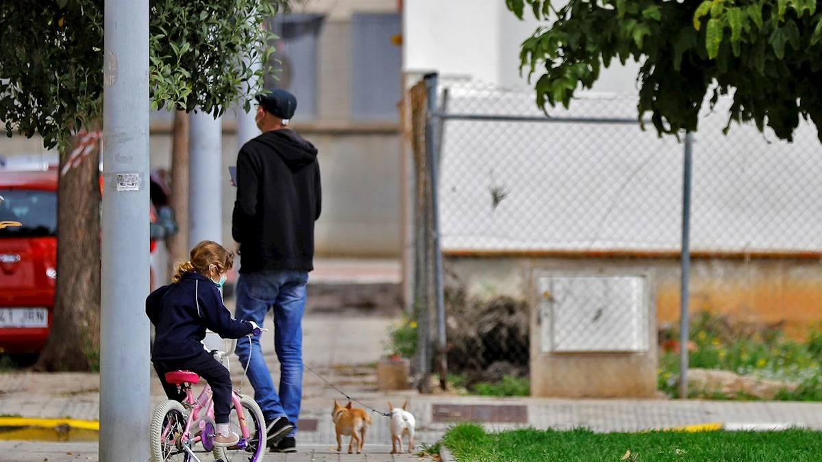 Una niña pasea junto a su padre en bicicleta