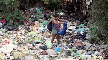 Una mujer busca entre la basura en Tegucigalpa (Honduras)