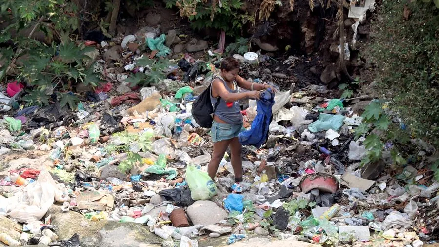 Una mujer busca entre la basura en Tegucigalpa (Honduras)