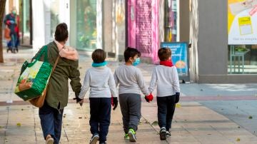 Tres niños acompañan a su madre a hacer la compra en Zaragoza