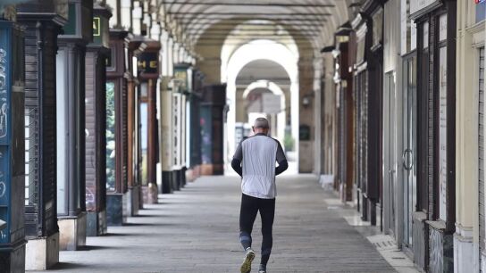 Un hombre camina por una calle vac&iacute;a de Tur&iacute;n.
