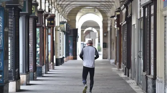 Un hombre camina por una calle vacía de Turín. Un hombre camina por una calle vacía de Turín.