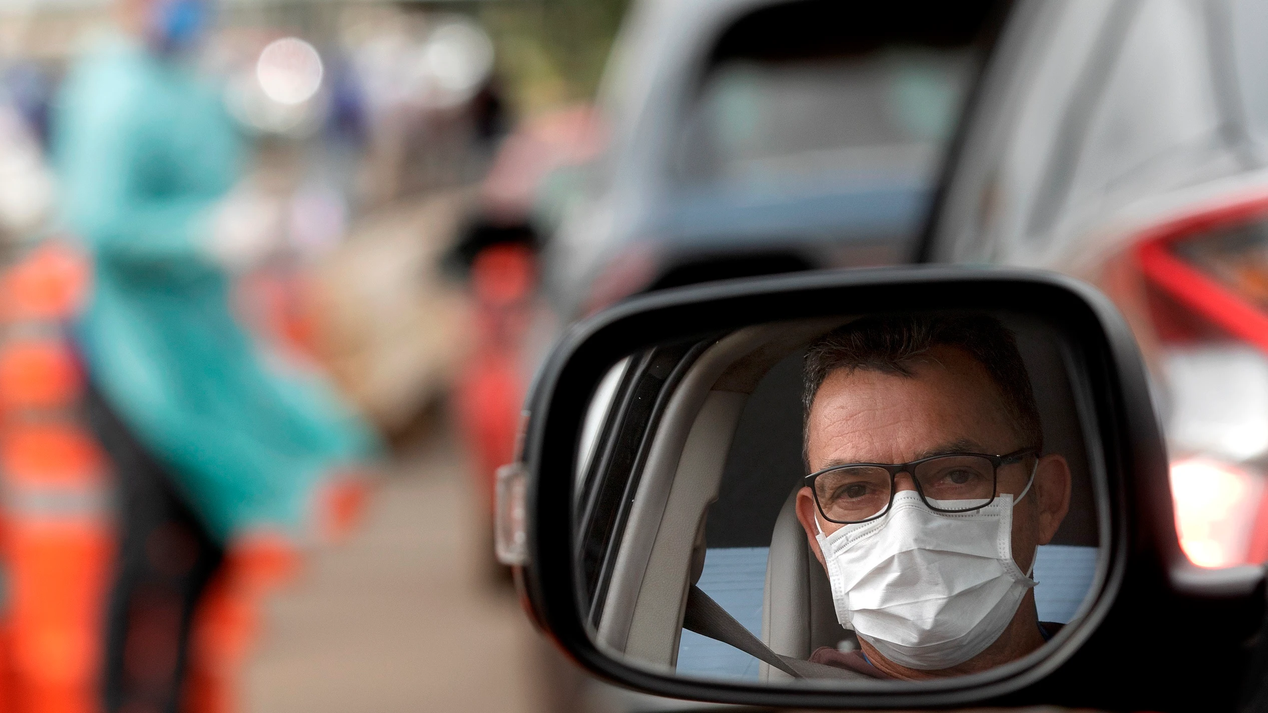 Un hombre con mascarilla en su coche