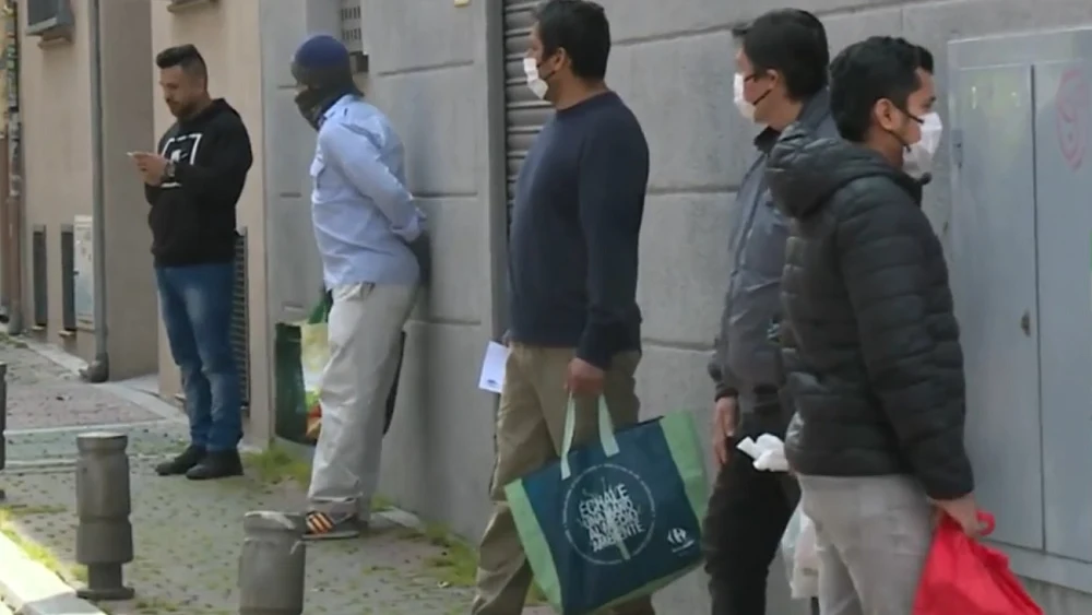 Imagen de personas esperando para recibir alimentos