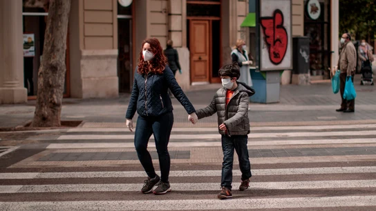Una mujer acompañada de un niño cruza una calle en Valencia coronavirus