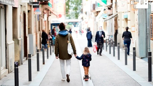 Un hombre y una niña caminan por el barrio de Gracia