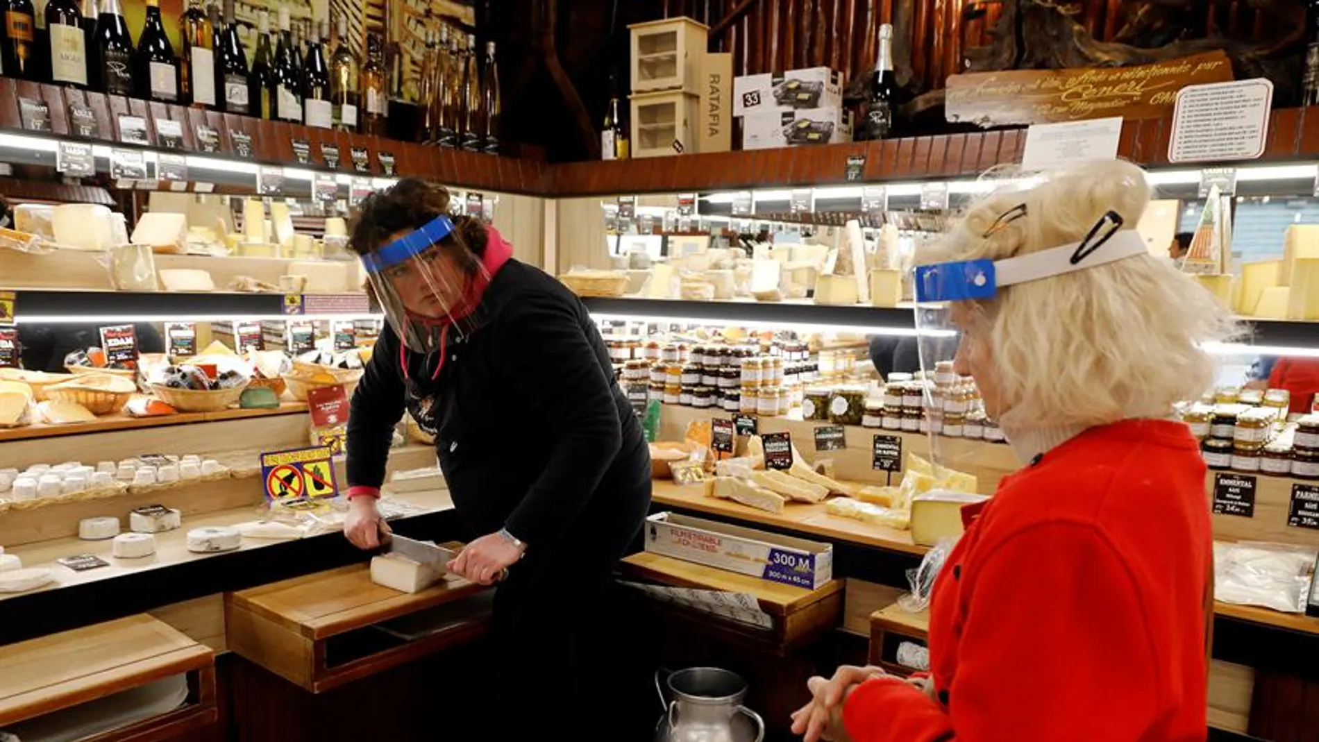 Una mujer compra en una tienda de quesos en Francia durante la pandemia de coronavirus