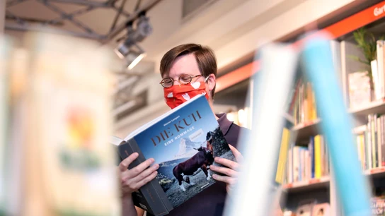 Un ciudadano lee un libro en una biblioteca de Alemania Un ciudadano lee un libro en una biblioteca de Alemania
