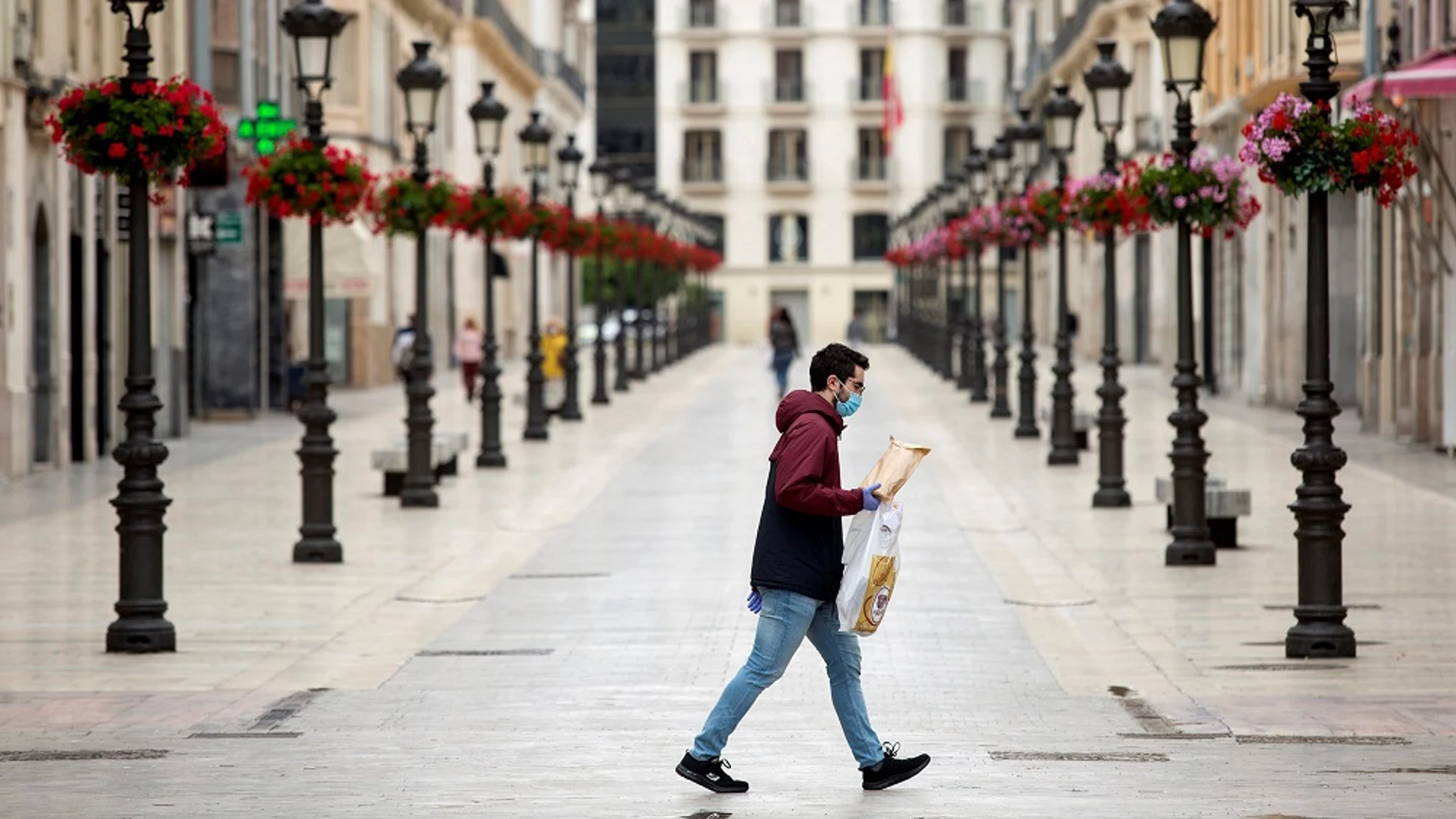 Una persona camina por la calle Larios, en Málaga