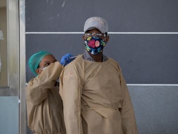 Una enfermera ayuda a un policía a cubrirse, mientras controlan el acceso al hospital Moscoso Puello este viernes, en Santo Domingo (República Dominicana), donde estas últimas semanas varias personas fueron ingresadas tras consumir consumo de clerén Una enfermera ayuda a un policía a cubrirse, mientras controlan el acceso al hospital Moscoso Puello este viernes, en Santo Domingo (República Dominicana), donde estas últimas semanas varias personas fueron ingresadas tras consumir consumo de clerén