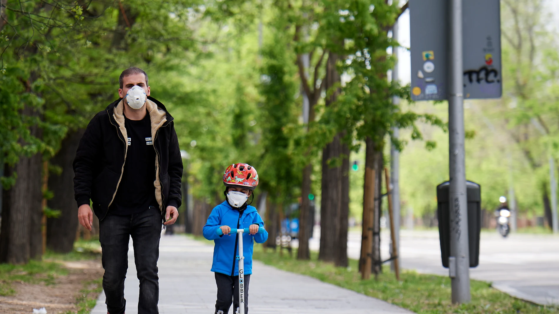 Un padre pasea con su hijo por las calles de Madrid