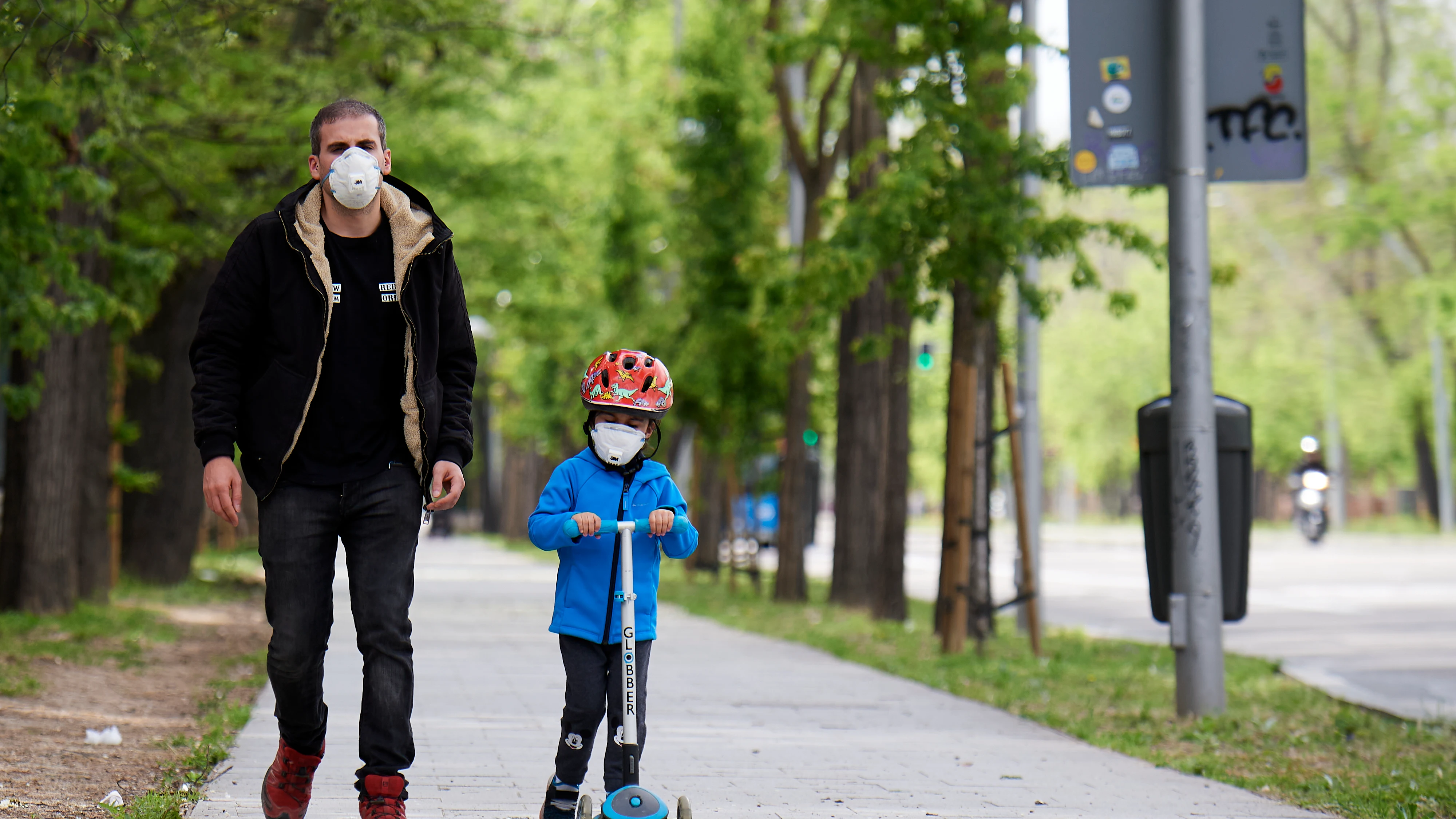 Un padre pasea con su hijo por las calles de Madrid