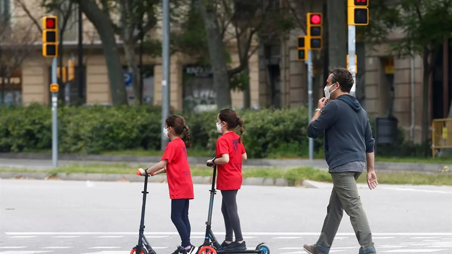 Un hombre y sus dos hijas caminan por una calle de Barcelona Un hombre y sus dos hijas caminan por una calle de Barcelona