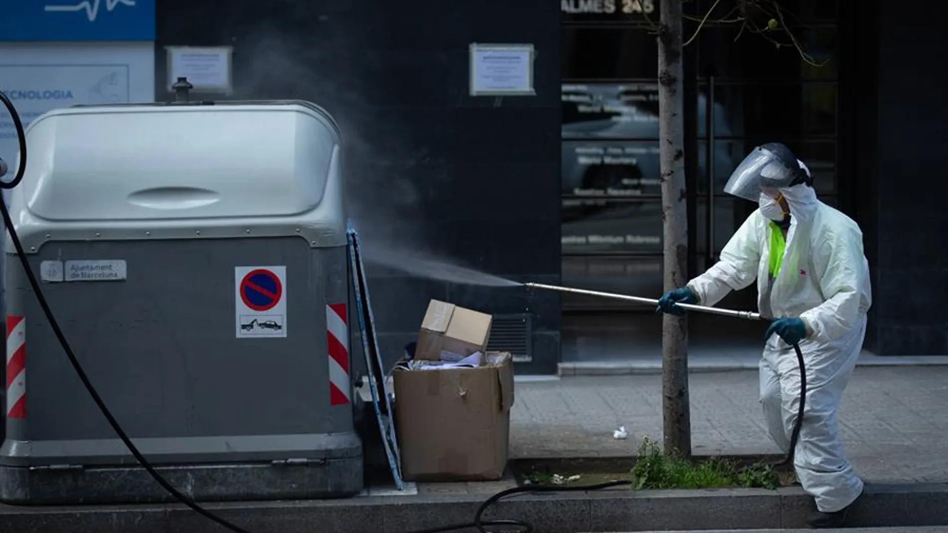 Un operario desinfecta un contenedor de basura en Barcelona
