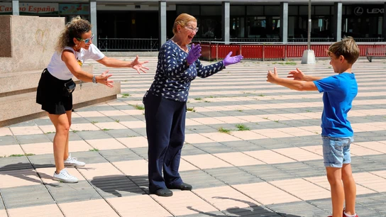 Un niño y su madre dan un "abrazo en la distancia" a la abuela en una plaza de Las Palmas de Gran Canaria durante el estado de alarma coronavirus