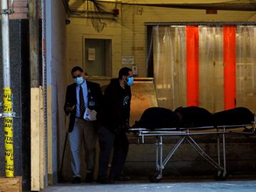 Un cuerpo es transportado a un vehículo funerario en el Hospital Mount Sinai West Un cuerpo es transportado a un vehículo funerario en el Hospital Mount Sinai West