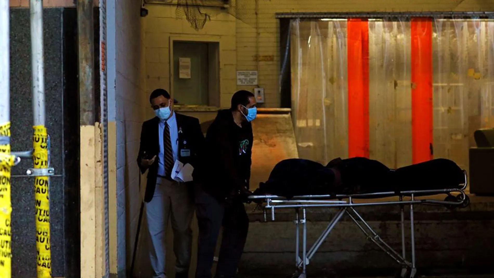 Un cuerpo es transportado a un vehículo funerario en el Hospital Mount Sinai West