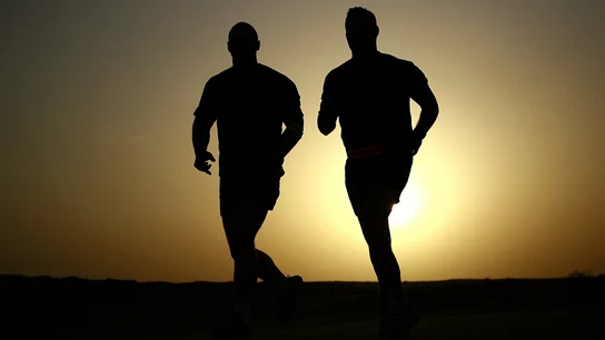 Imagen de dos personas corriendo al atardecer Imagen de dos personas corriendo al atardecer