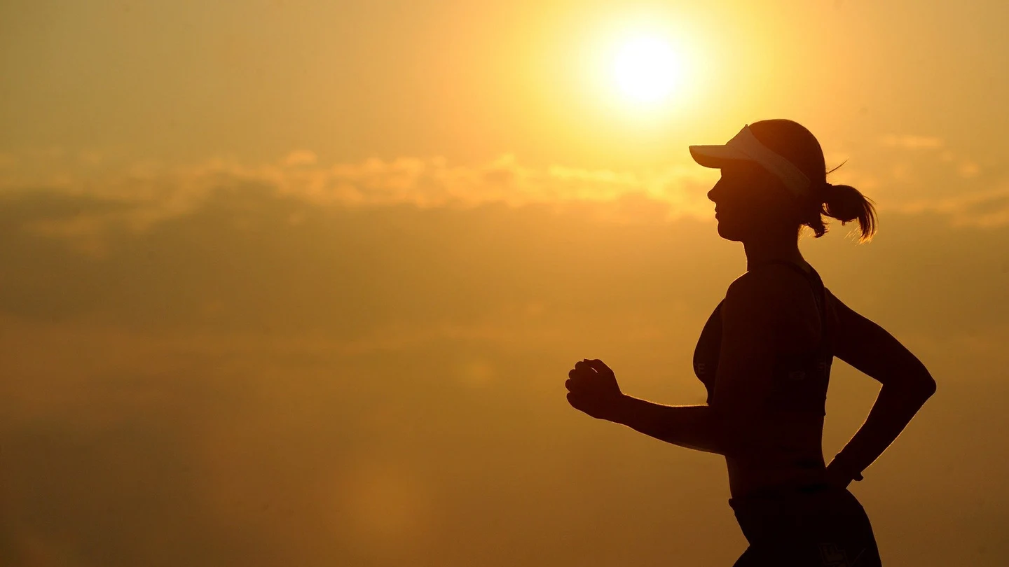 Una mujer sale a correr al atardecer Una mujer sale a correr al atardecer