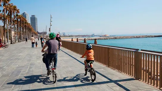 Una familia circula en bici por el paseo marítimo de Barcelona Una familia circula en bici por el paseo marítimo de Barcelona