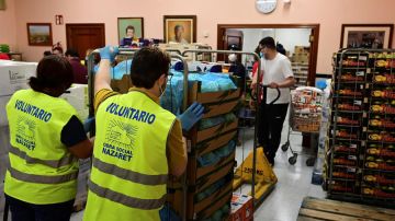 Varios voluntarios preparan lotes de alimentos para personas necesitadas