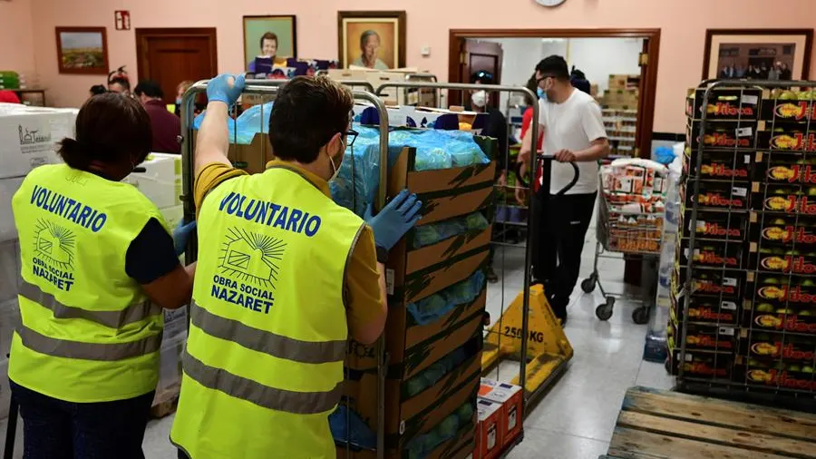 Varios voluntarios preparan lotes de alimentos para personas necesitadas